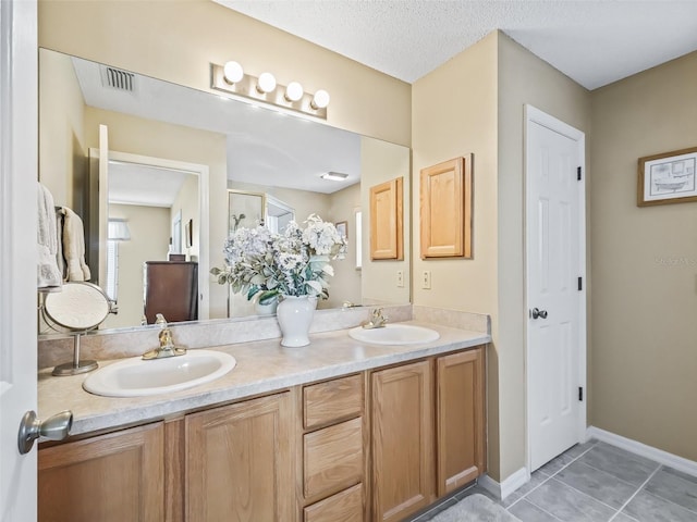 bathroom featuring vanity, tile patterned flooring, and a textured ceiling