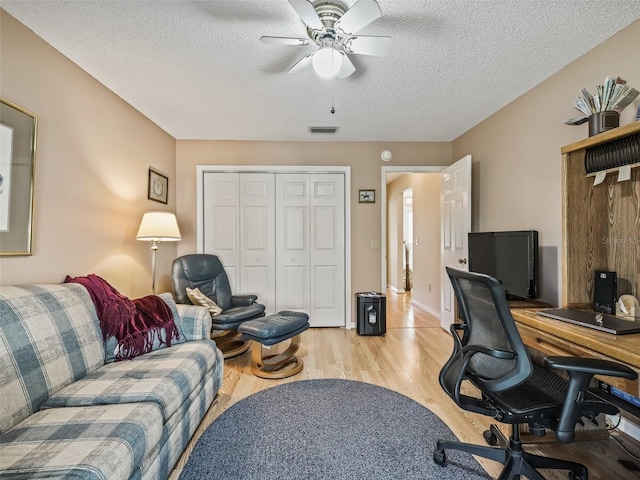 office space featuring ceiling fan, a textured ceiling, and light wood-type flooring