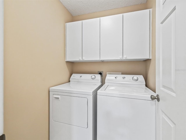 clothes washing area featuring independent washer and dryer, cabinets, and a textured ceiling