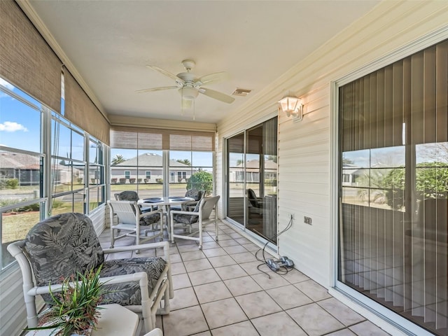 sunroom featuring ceiling fan and plenty of natural light