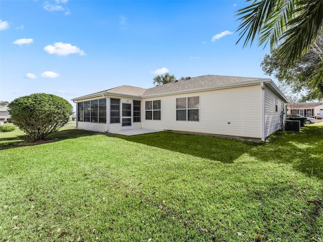 back of property featuring central AC, a sunroom, and a lawn