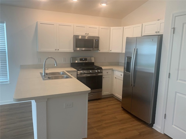 kitchen with kitchen peninsula, appliances with stainless steel finishes, sink, and white cabinetry