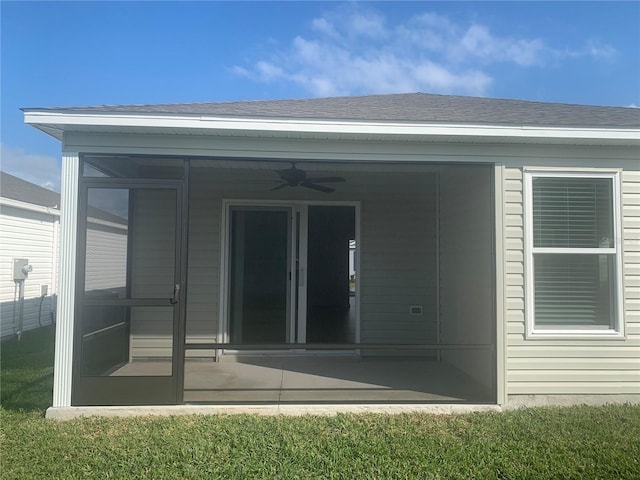 rear view of house featuring ceiling fan, a yard, and a sunroom