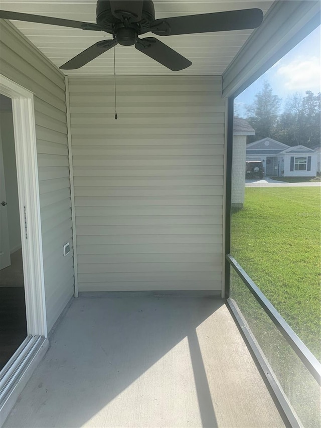 unfurnished sunroom with ceiling fan