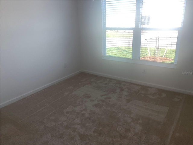 spare room with dark carpet