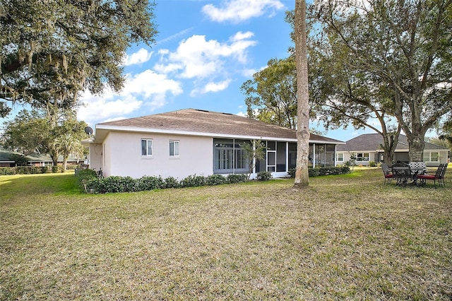 back of property with a sunroom and a yard