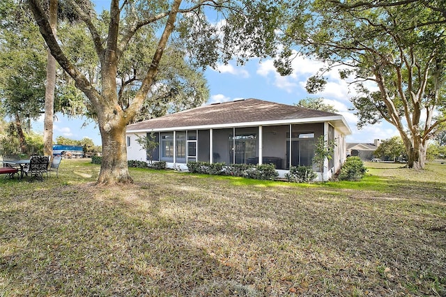 back of house with a lawn and a sunroom