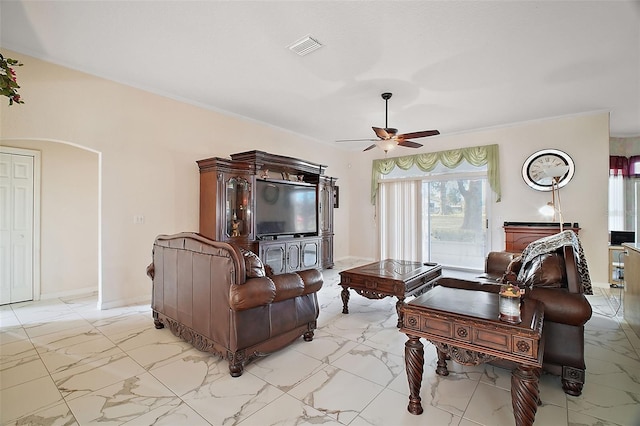 living room with ceiling fan and ornamental molding