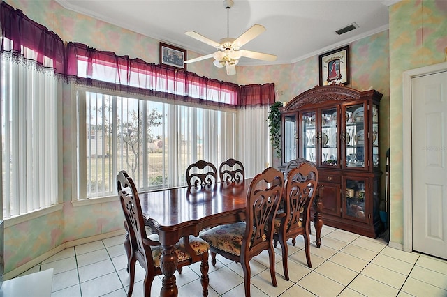 dining space with ceiling fan, light tile patterned floors, and crown molding