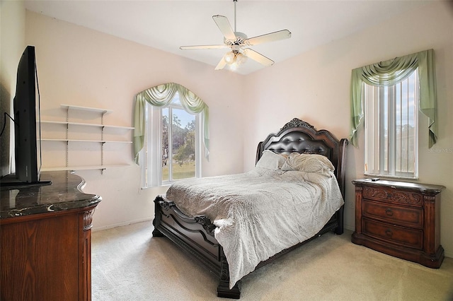 carpeted bedroom with ceiling fan and multiple windows