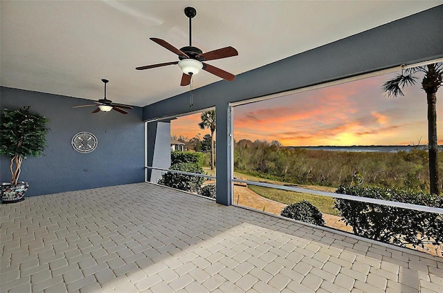 patio terrace at dusk featuring ceiling fan