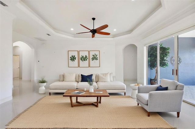 living room featuring ceiling fan and a tray ceiling