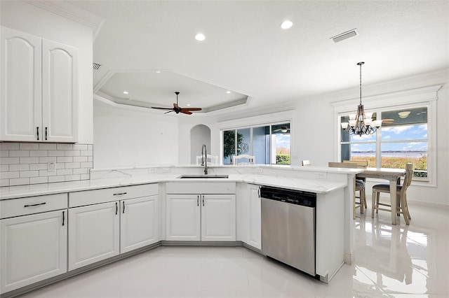 kitchen featuring dishwasher, white cabinetry, sink, kitchen peninsula, and a tray ceiling