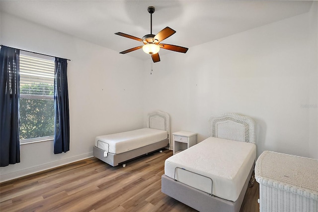 bedroom featuring wood-type flooring, multiple windows, and ceiling fan