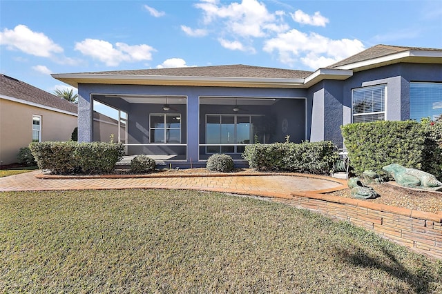 rear view of house featuring a sunroom, a lawn, and ceiling fan