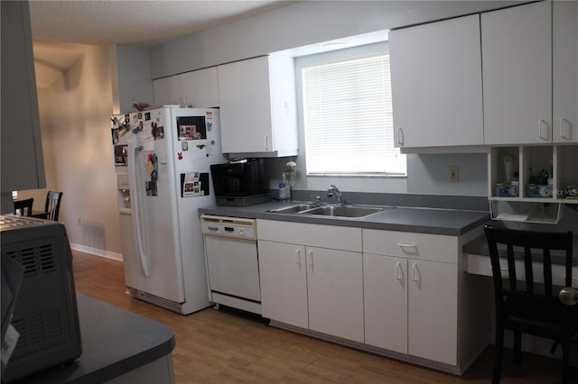 kitchen with sink, white appliances, light wood-type flooring, a textured ceiling, and white cabinets