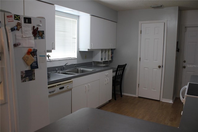 kitchen featuring white cabinetry, sink, dark hardwood / wood-style flooring, and white appliances