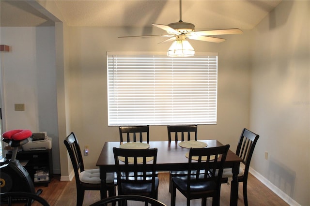 dining area with ceiling fan, dark hardwood / wood-style floors, and lofted ceiling