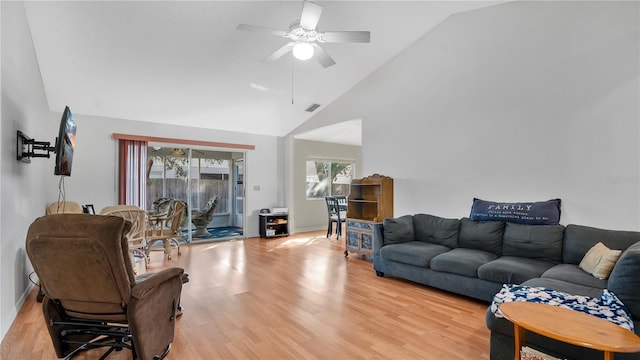 living room with ceiling fan, lofted ceiling, and light hardwood / wood-style flooring