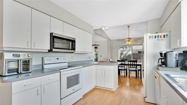 kitchen with light hardwood / wood-style floors, white cabinets, white appliances, and kitchen peninsula