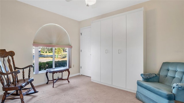 living area with light colored carpet and ceiling fan