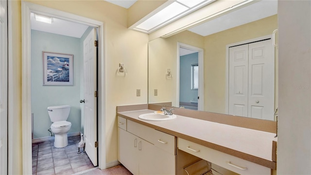 bathroom with vanity, toilet, and a skylight