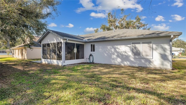 rear view of property with a lawn and a sunroom