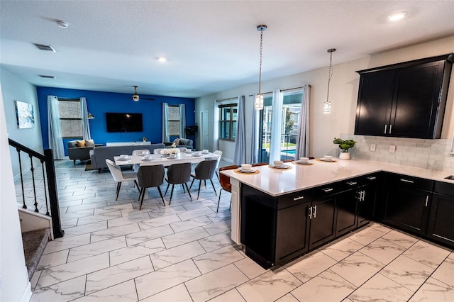 1257 Challenge Dr, Davenport, FL 33896 - kitchen with open floor plan, light marble finish floors, dark cabinets, light countertops, and recessed lighting