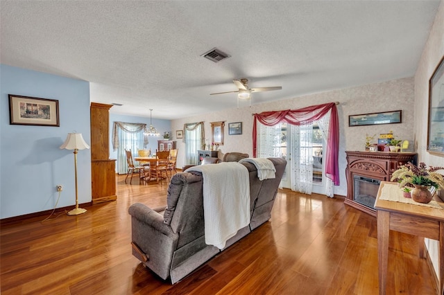 living room featuring ceiling fan, hardwood / wood-style flooring, and a textured ceiling