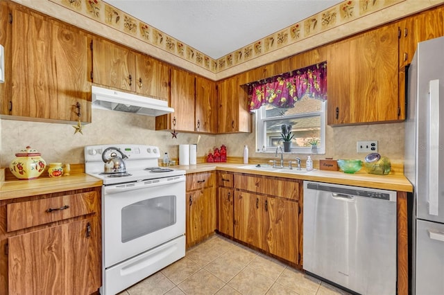 kitchen featuring sink, stainless steel appliances, and light tile patterned flooring