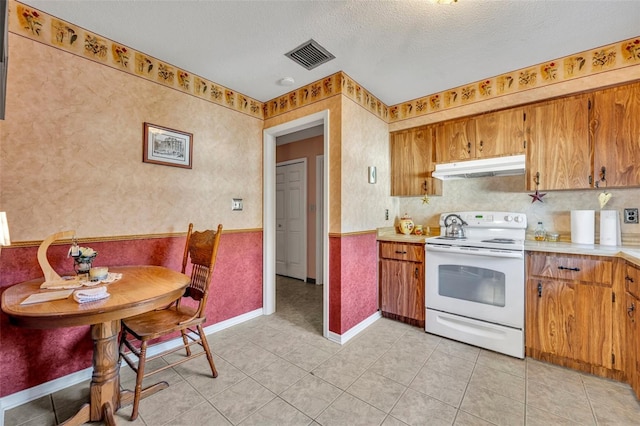 kitchen featuring light tile patterned flooring, a textured ceiling, and white range with electric stovetop