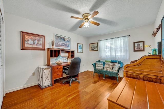 office space featuring hardwood / wood-style flooring, ceiling fan, and a textured ceiling