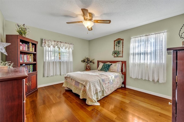 bedroom featuring a textured ceiling, wood-type flooring, and ceiling fan