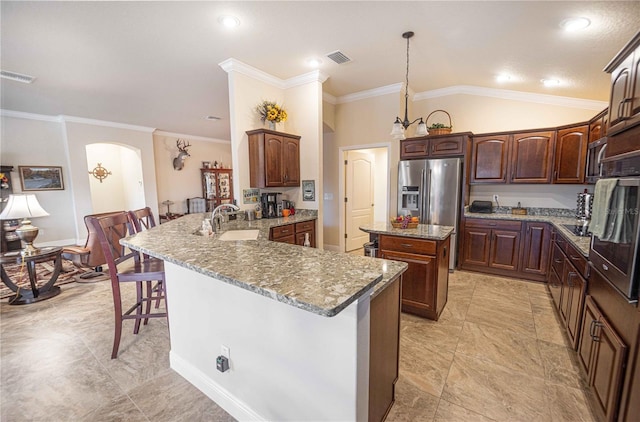 kitchen with a center island, a kitchen bar, hanging light fixtures, kitchen peninsula, and high end refrigerator