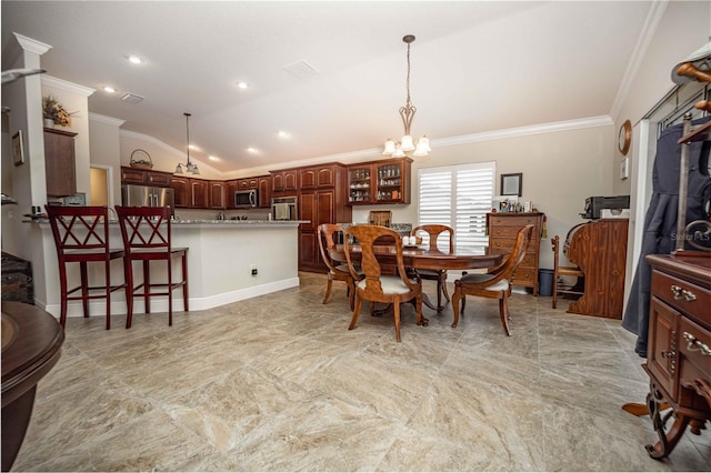 dining room with crown molding, lofted ceiling, and an inviting chandelier