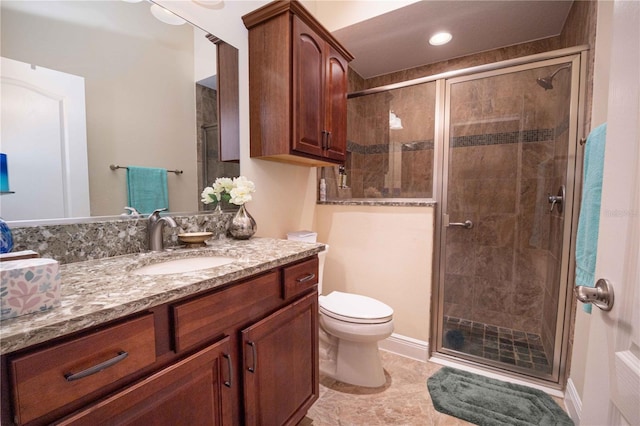 bathroom featuring toilet, walk in shower, and vanity