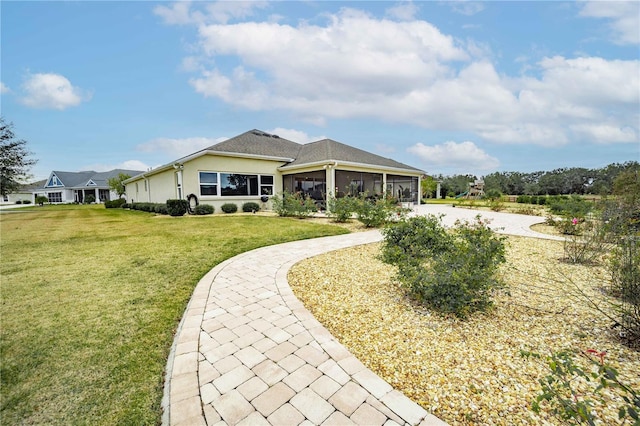 rear view of house featuring a sunroom and a lawn