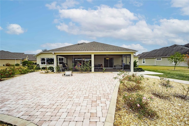 rear view of property with a lawn and a sunroom