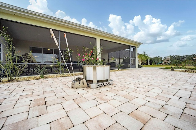 view of patio with a sunroom and a playground