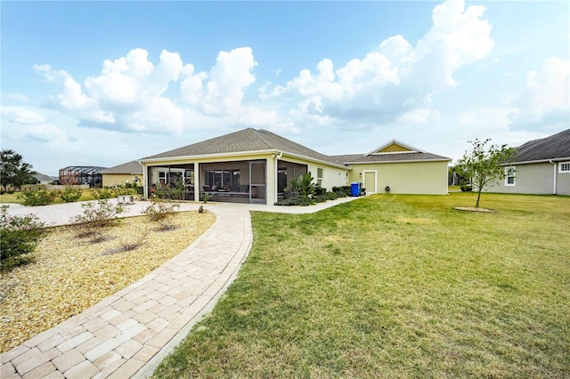 rear view of house with a lawn and a sunroom