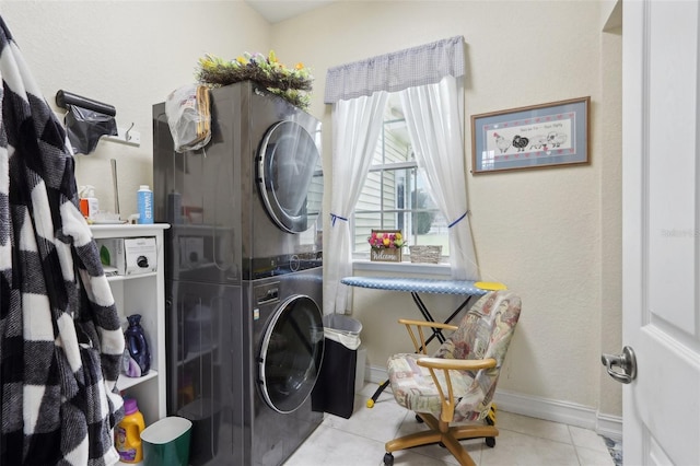 laundry area featuring light tile patterned flooring and stacked washer / drying machine