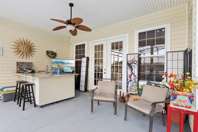 view of patio with an outdoor bar, ceiling fan, and french doors