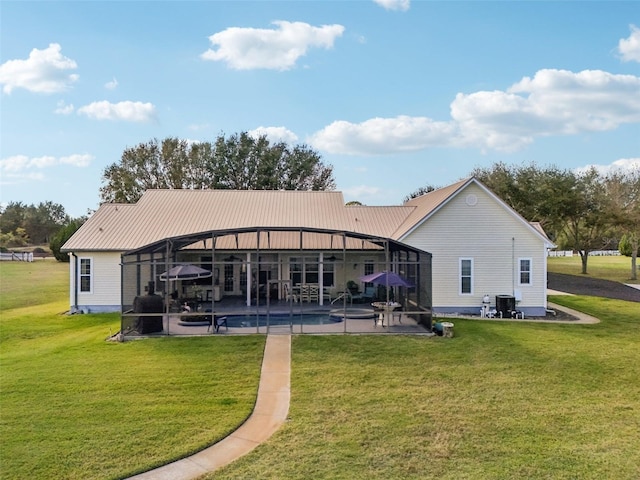 rear view of house with a patio, a lanai, and a lawn