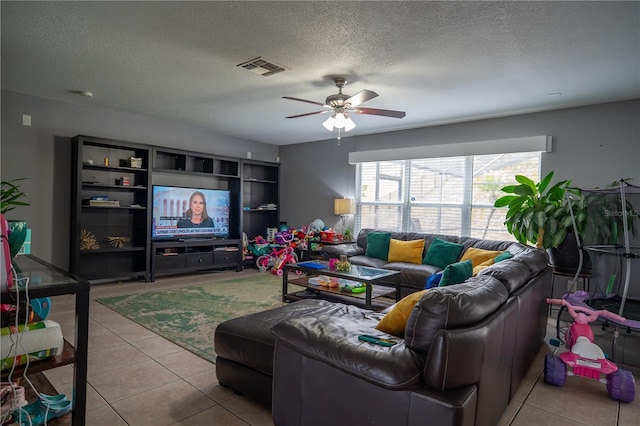 tiled living room with ceiling fan and a textured ceiling