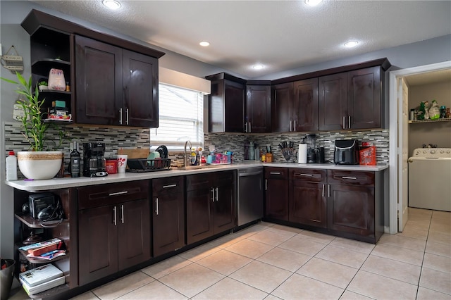 kitchen with dishwasher, washer / dryer, sink, light tile patterned floors, and dark brown cabinets