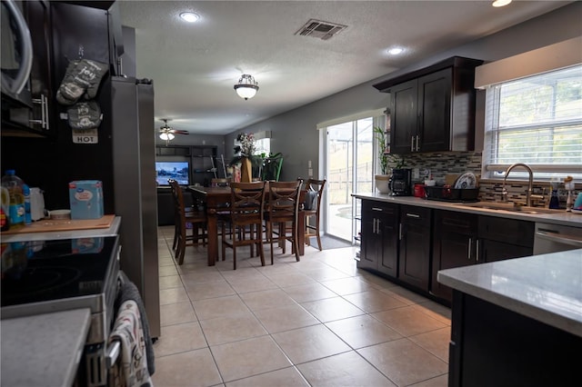 kitchen with tasteful backsplash, appliances with stainless steel finishes, sink, and a textured ceiling