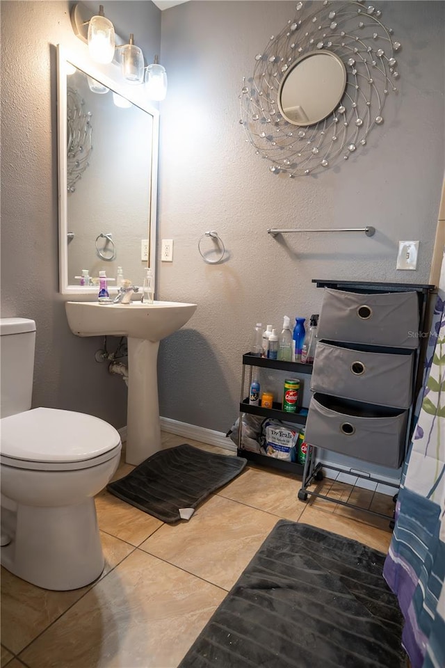 bathroom with toilet and tile patterned flooring