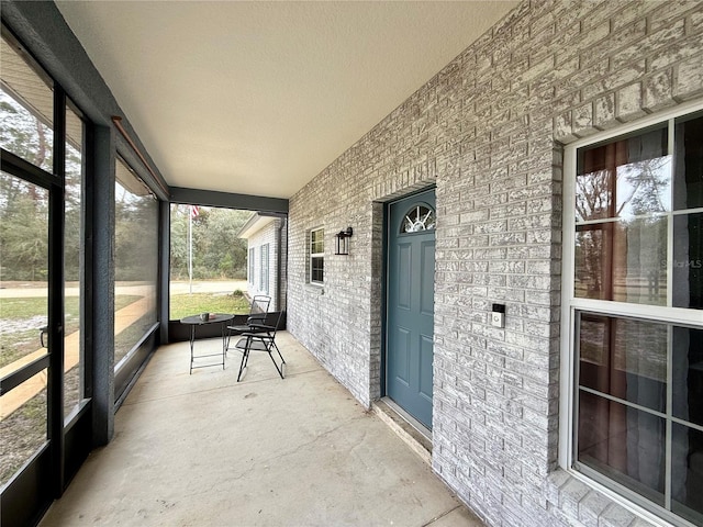 unfurnished sunroom featuring vaulted ceiling and a healthy amount of sunlight