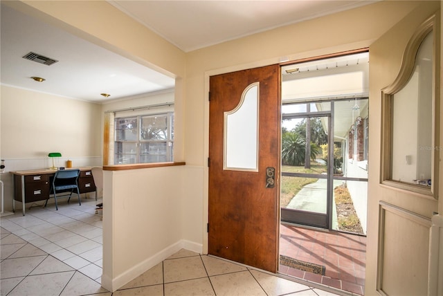 tiled foyer featuring crown molding