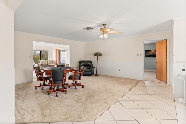 carpeted dining space with ceiling fan